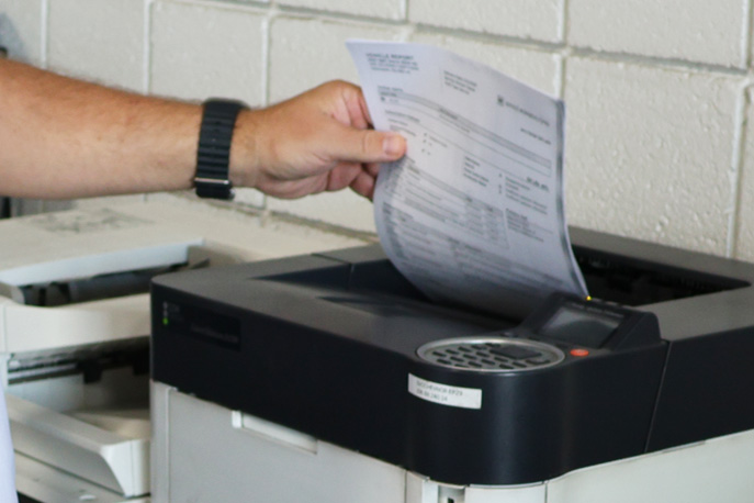 Service writer getting eAdvisor report off of printer